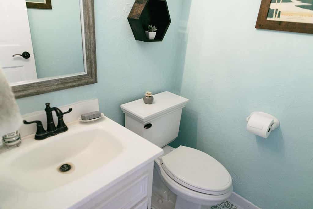 A bathroom with blue walls and a white toilet.