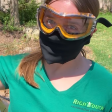 A woman wearing a green shirt and goggles.