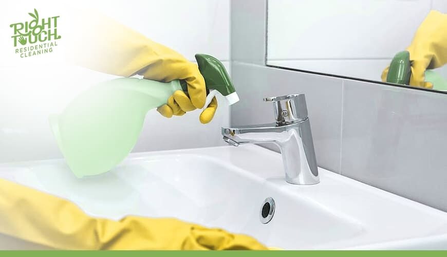 A person in yellow gloves cleaning a sink.