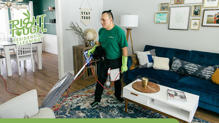 A man in a green shirt providing housekeeping services in a living room.