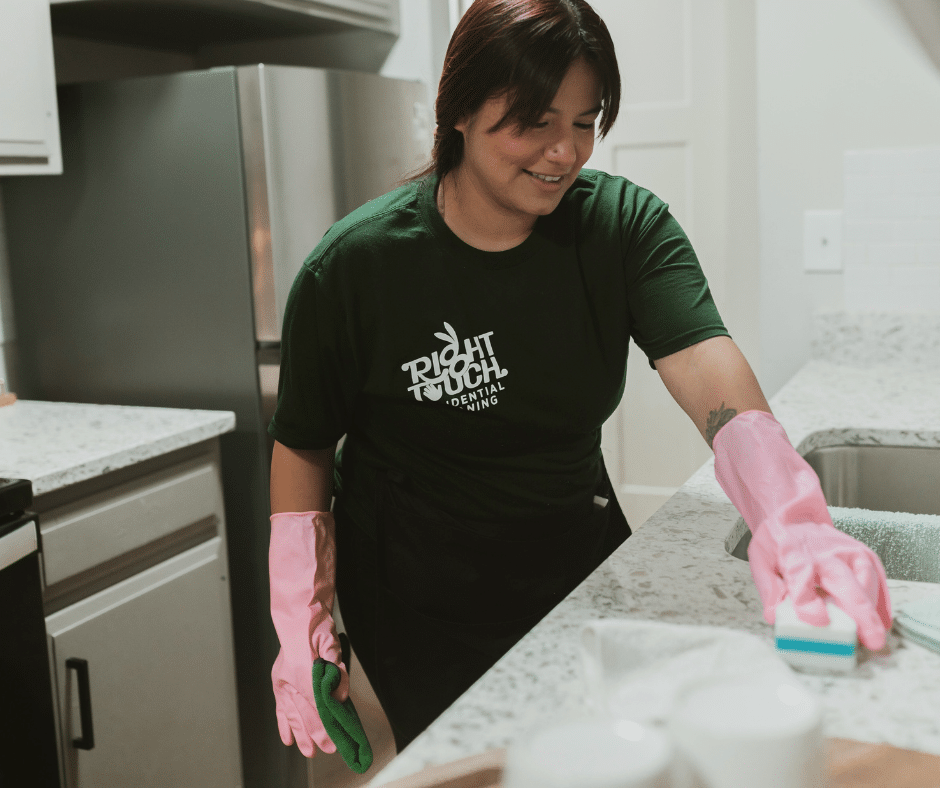 Woman cleaning technician wiping counter wearing pink gloves