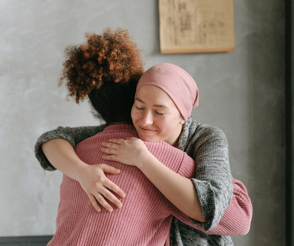 Woman hugging another woman who is fighting cancer