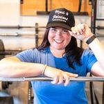 Smiling female owner of local organizing company wearing a black company hat